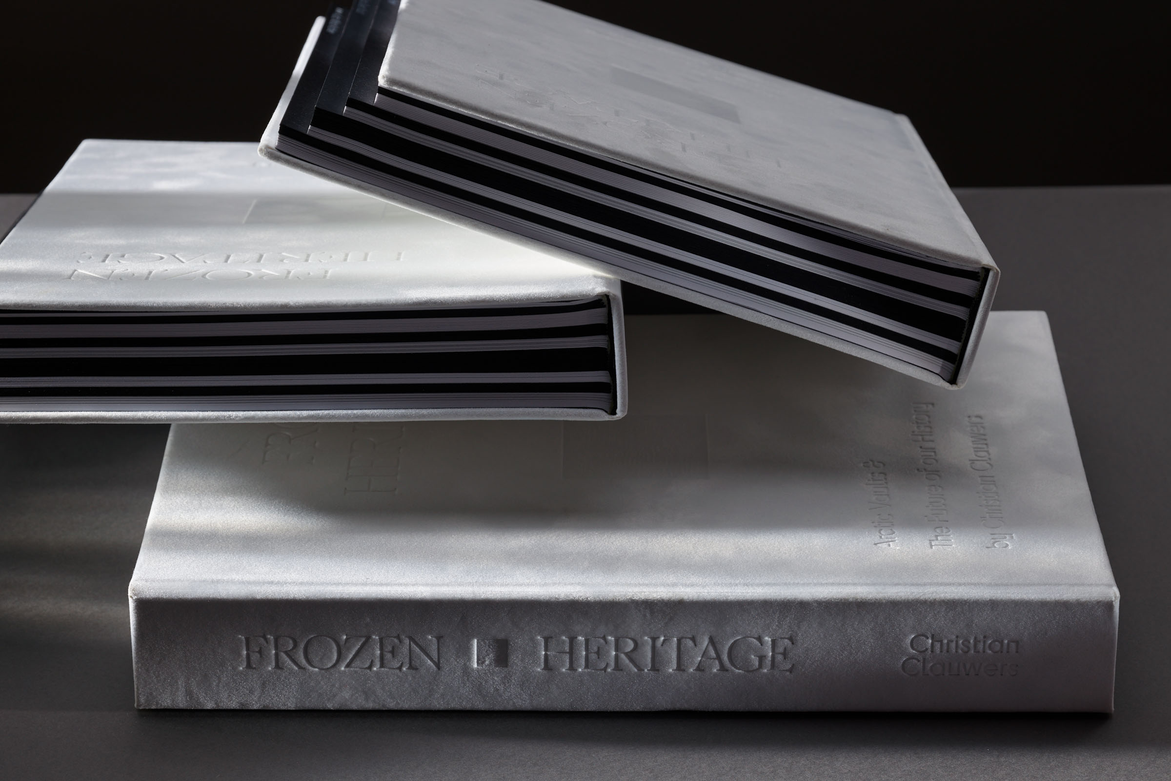Stapel luxe boeken Frozen Heritage met zichtbare debossing en contrasterend binnenwerk in zwart-wit ontwerp door Tina De Souter