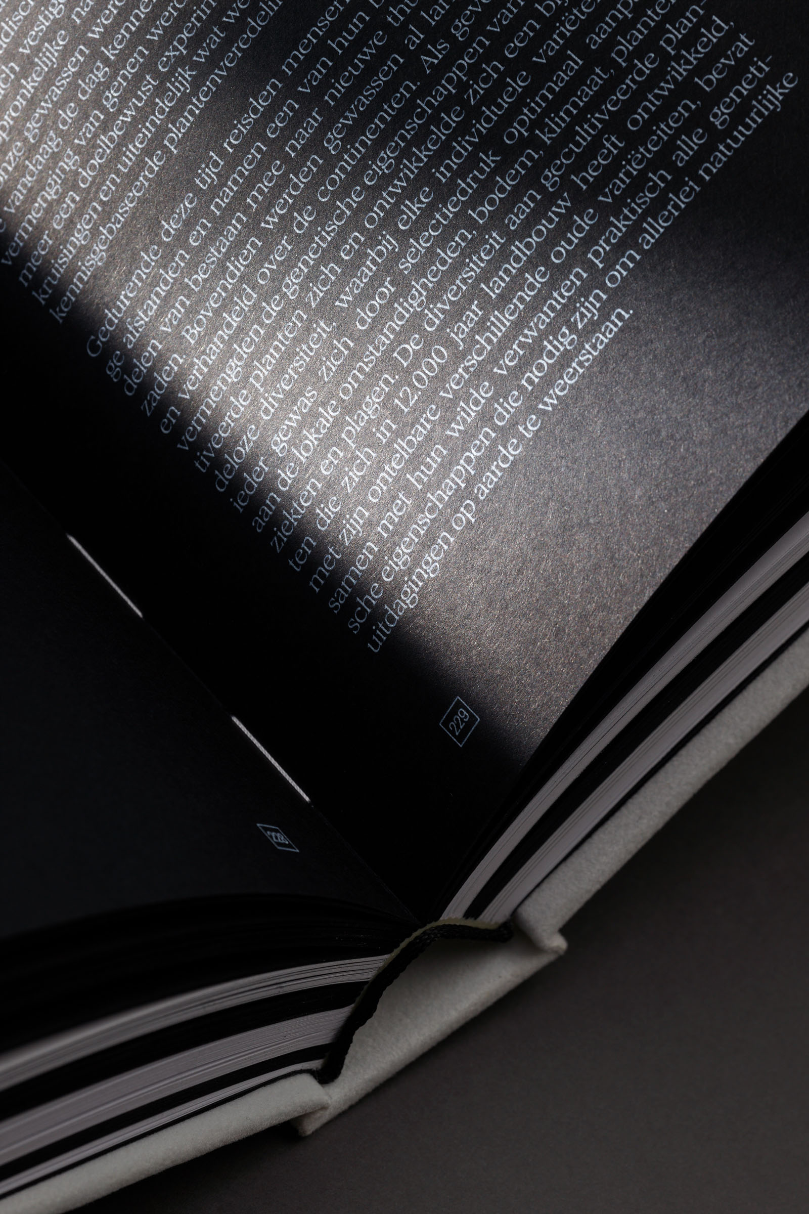 Luxe drukwerk met witte inkt op zwart papier, detail van typografie in Frozen Heritage, premium afwerking door Buroform